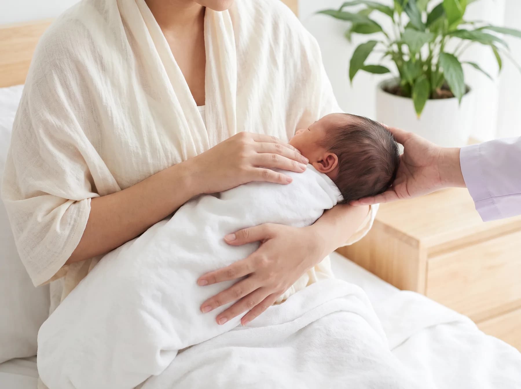 Điều dưỡng chỉnh tư thế bế cho mẹ đang cho bé bú